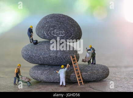 Pile de cailloux et de travailleurs figurines Banque D'Images