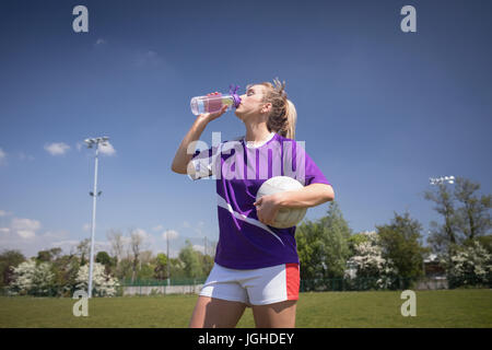 Soif de football avec ballon d'eau potable sur terrain against sky Banque D'Images