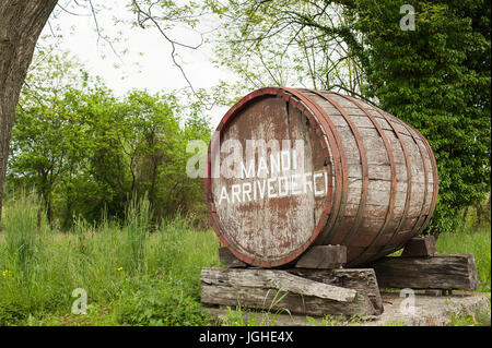 Vieux baril indiquant le début d'une zone de production de vin de raisin. L'inscription sur le canon dit 'au revoir'. En Italien et en frioulan d Banque D'Images