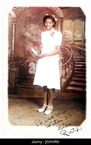 Portrait de jeune femme afro-américaine en blanc robe longueur genou, debout en face de Fresco, 1920. Remarque : l'image a été colorisée numériquement à l'aide d'un processus moderne. Les couleurs peuvent ne pas être exacts à l'autre. Banque D'Images