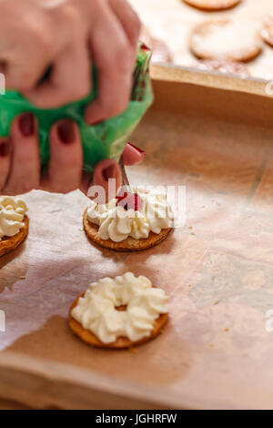 Chef pâtissier Décorer un gâteau avec la crème fouettée et de confiture Banque D'Images