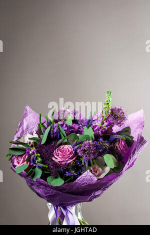 Bouquet romantique de l'auteur de diverses couleurs de violet purple dans un vase en verre transparent Banque D'Images