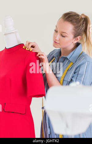 Designer de mode féminine travaillant sur mannequin en Studio Banque D'Images