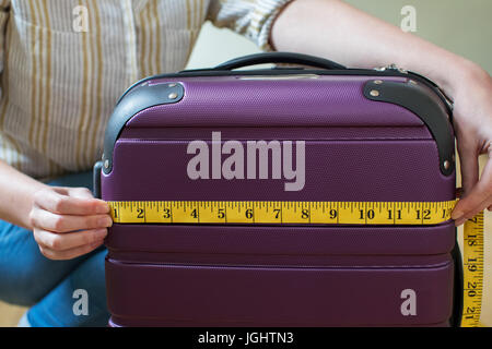 Close Up of Woman Measuring valise avant Maison de Vacances Banque D'Images