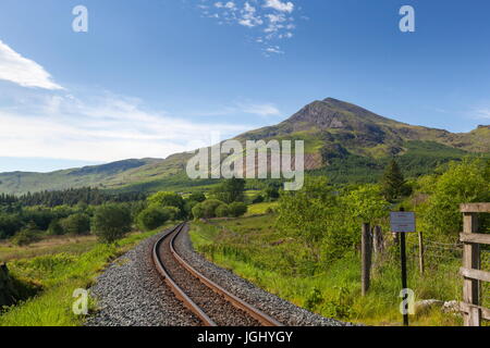 Moel Hebog vue du bord de l'assiette de la forêt de Beddgelert avecle du Welsh Highland Railway dans le premier plan Banque D'Images