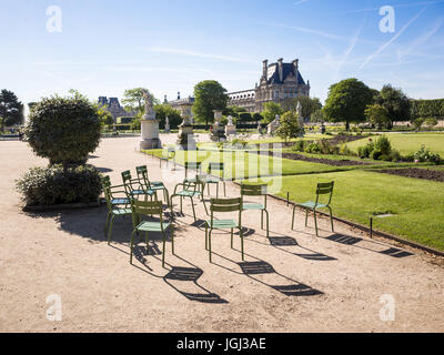 Vue sur le jardin des Tuileries à Paris, en France, par un matin ensoleillé avec le célèbre de chaises de jardin en métal et le pavillon de Flore du palais du Louvre. Banque D'Images