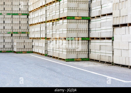 Des piles de blocs de béton empilés sur des palettes en bois à l'extérieur. Banque D'Images