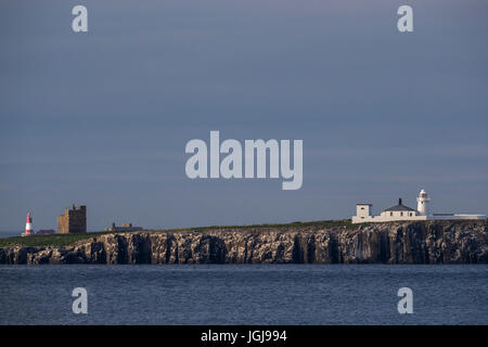 Phare rouge et blanc Longstone derrière la balise plus Brownsman tour sur l'île. Farne intérieur très lumineux à l'avant. Iles Farne, UK. Banque D'Images