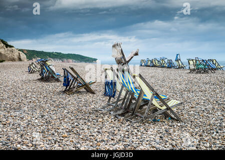 Chaises longues sur une plage de vent Banque D'Images