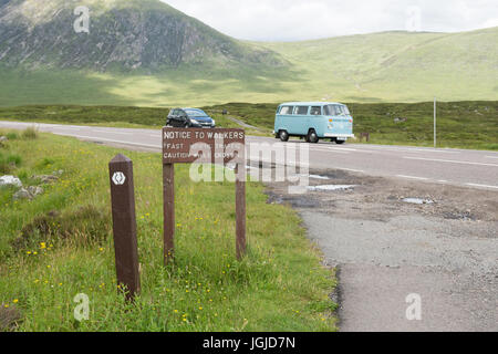 West Highland Way sign attention marcheurs de se méfier de la circulation se déplaçant rapidement en traversant la route A82, à Glencoe, en Écosse, Royaume-Uni Banque D'Images