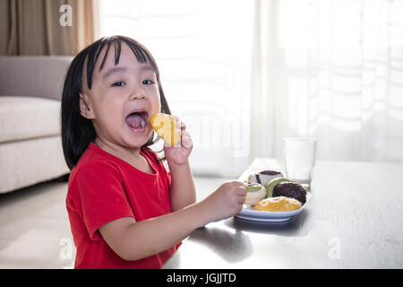 Chinois asiatique petite fille prendre le petit déjeuner dans la salle de séjour à la maison Banque D'Images