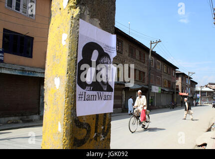 Srinagar, au Cachemire. 08 juillet, 2017. Photo de burhan wani coller sur le sondage électrique en tant que cycliste chevauche son vélo ,lorsque le couvre-feu comme aujourd'hui les autorités.Des restrictions imposées strict couvre-feu comme restrictions cachemire pour maintenir la loi et l'ordre que les accolades de la vallée pour le premier anniversaire de la mort de Hizbul Mujahideen 'commander' Burhan Wani . Credit : Sofi suhail/Alamy Live News Banque D'Images