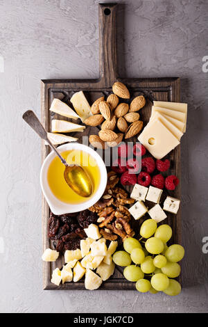 Assiette de fromage aux noix, miel et raisins Banque D'Images