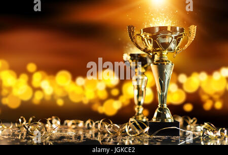 Golden Champion trophy sur table en bois avec spots flou sur l'arrière-plan. Copyspace pour texte, bannière large format. Concept de la réussite et l'accomplissement. Banque D'Images