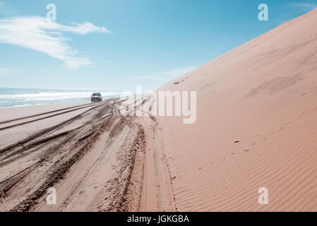 Un 4x4 le long de la plage en Namibie's Sandwich Harbour. Banque D'Images