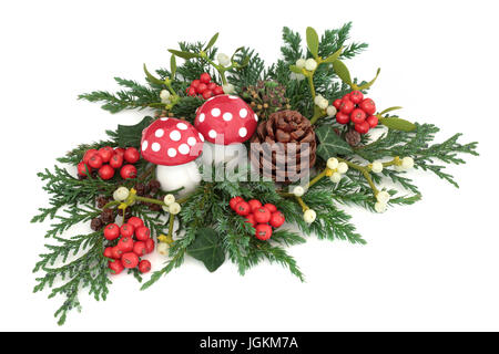 Décoration de Noël avec des ornements de champignons agaric fly, de houx, de lierre, de gui, de cèdre et de genévrier branches de pin et de feuilles sur fond blanc. Banque D'Images