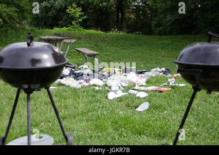 Les ordures laissées dans l'herbe après un barbecue et des festivités a pris fin. Banque D'Images