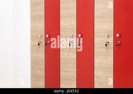 Sports en bois rouge armoire dans la salle de sport pour les vêtements avec des touches mettalic Banque D'Images