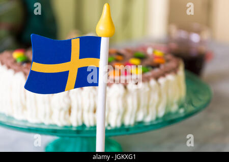 Petit drapeau suédois en bois sur la table en face de gâteau joliment décoré pendant la célébration communiqué de modèle : N° des biens : Non. Banque D'Images