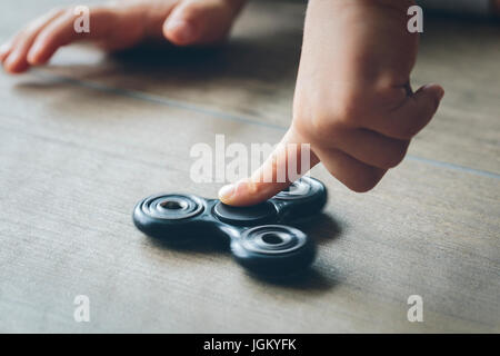 Libre de la main d'un enfant jouant avec un spinner fidget Banque D'Images