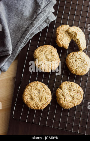 Sans gluten biscuits faits maison et une serviette sur la grille de refroidissement. La verticale. Focus sélectif. Les tons de lumière Banque D'Images