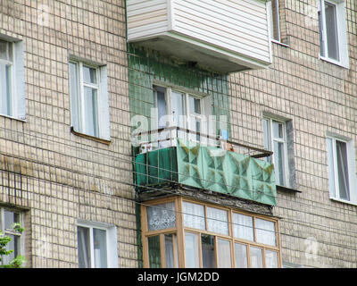 Vieux bâtiment de style soviétique avec Khrushchyovka appartement balcon vert et mur carrelé Banque D'Images