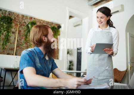 Jolie waitress de l'un d'invités Banque D'Images