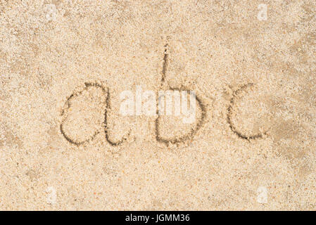 Abc abc écrit en fond de sable Banque D'Images