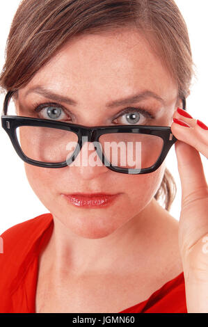 Une belle jeune femme tenant ses lunettes noires, à la recherche sur les verres avec de beaux yeux bleus, isolée pour fond blanc. Banque D'Images