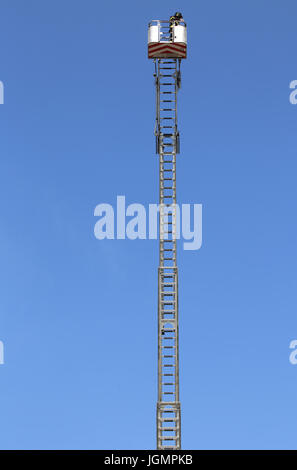 Panier avec plate-forme aérienne sur la très longue échelle spéciale d'un camion à incendie et ciel bleu en arrière-plan Banque D'Images