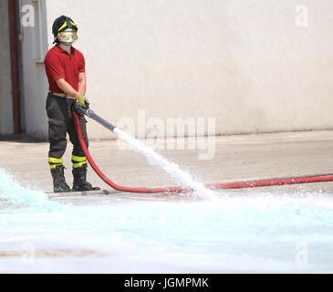 Pompier à la borne fontaine l'esprit de tester le débit de l'eau pendant l'exercice dans le poste d'incendie Banque D'Images