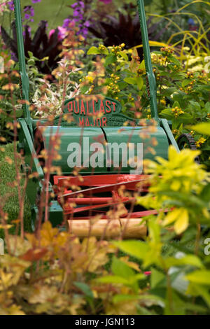 Les plantes, les arbustes et la vieille tondeuse poussée dans le magnifique jardin d'affichage - Chatsworth RHS Flower Show showground, Chatsworth House, Derbyshire, Angleterre, Royaume-Uni. Banque D'Images