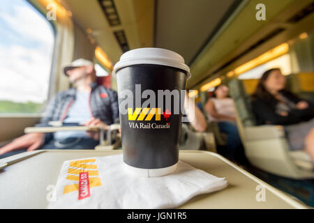 Intérieur de l'autorail sur un train ViaRail, à destination de Toronto, avec une tasse de café en papier de Via Rail en premier plan Banque D'Images