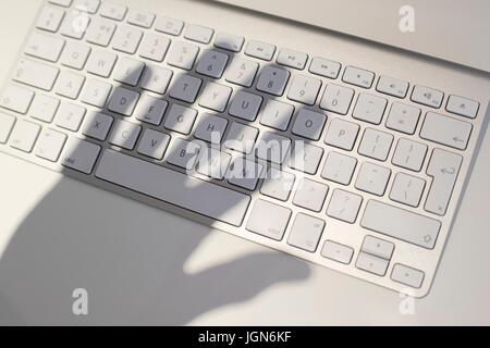 Plus keywboard casted d'ombres, conceptual image de cyber-criminalité. Banque D'Images