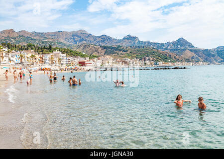 GIARDINI NAXOS, ITALIE - 28 juin 2017 : les gens de mer près de waterfront de Giardini-Naxos et ville de Taormina vue sur la ville du Cap. Giardini Naxos est seasi Banque D'Images