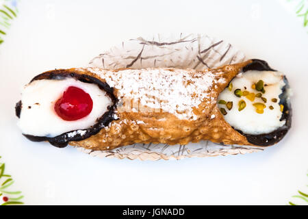 Vue de dessus de la pâtisserie Sicilienne typique Cannolo saupoudrée de sucre glace on white plate Banque D'Images