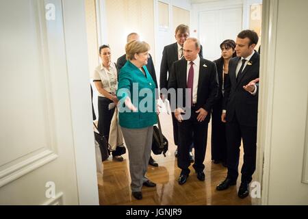 La chancelière allemande, Angela Merkel, escorte le Président russe Vladimir Poutine, centre, et le président français, Emmanuel Macron avant une réunion trilatérale en marge de la réunion au sommet du G20 le 8 juillet 2017 à Hambourg, Allemagne. (Bundesregierung/Kugler par Planetpix) Banque D'Images