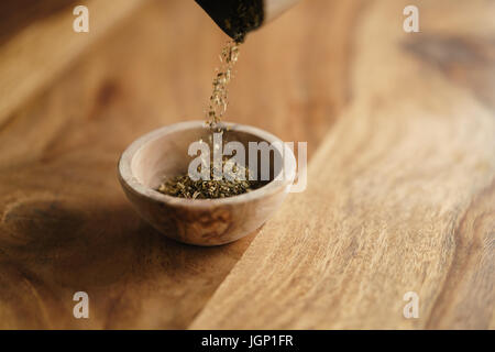 Provence séchées herb mix tomber dans un bol en bois pour l'assaisonnement sur table Banque D'Images