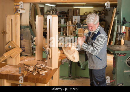 Masque en bois à l'aide d'outils de sculpture sur bois sculpteur sur un bloc de bois, masque de bois carver, Workbench, Bad Aussee, Styrie, Autriche Banque D'Images