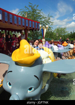 Une mère et son enfant ride le Dumbo l'éléphant volant ride at Disneyland Paris Banque D'Images