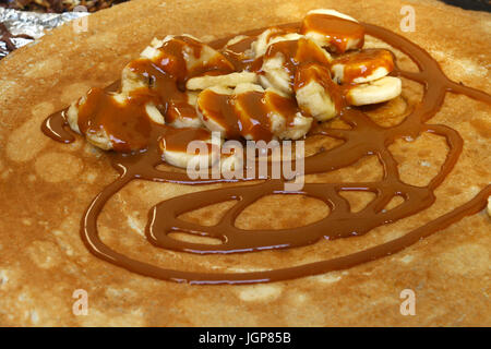 Crêpes français avec la banane et chocolat préparé sur le gril pendant le jour de la Bastille foire de rue Banque D'Images