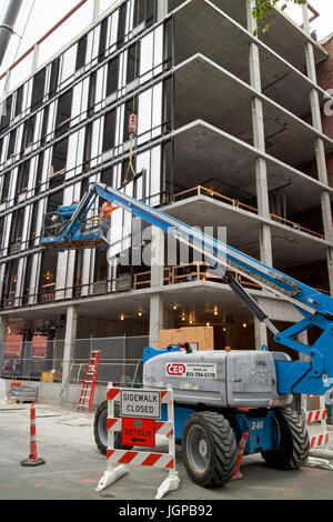 Cherry picker plate-forme surélevée, guider des panneaux de construction sur chantier de Boston USA Banque D'Images