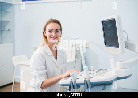 Smiling doctor, échographie. Le médecin effectue une échographie. Banque D'Images