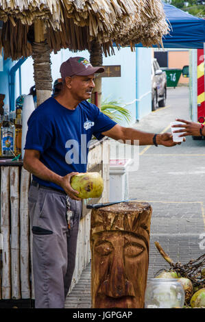 Man chopping coco rhum dans un verre au bar Coconut à Belize City, Belize Banque D'Images