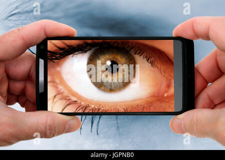 A woman's eye dans un appareil photo téléphone mobile, gawker Banque D'Images