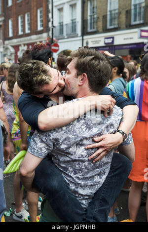 Une scène de rue de Soho à Londres. Gay Men kissing profiter de l'ambiance de fête de rue de Soho, après la Gay Pride, Pride Parade annuelle de Londres. Coming out gay. Banque D'Images