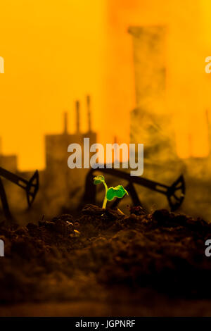 Jeune plante verte dans le sol sur l'huile de la machine bascule en arrière-plan Banque D'Images