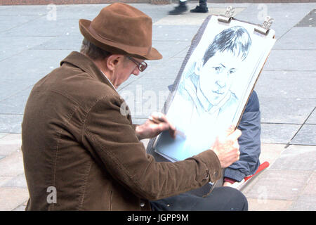 Artiste de rue sur Buchanan Street Glasgow dessiner un portrait d'un jeune garçon Banque D'Images