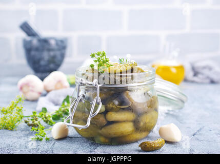 Picled au concombre et banque en verre sur une table Banque D'Images