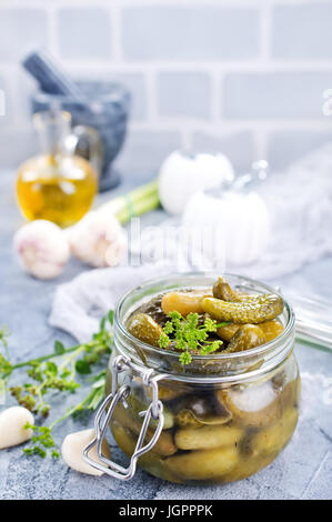 Picled au concombre et banque en verre sur une table Banque D'Images